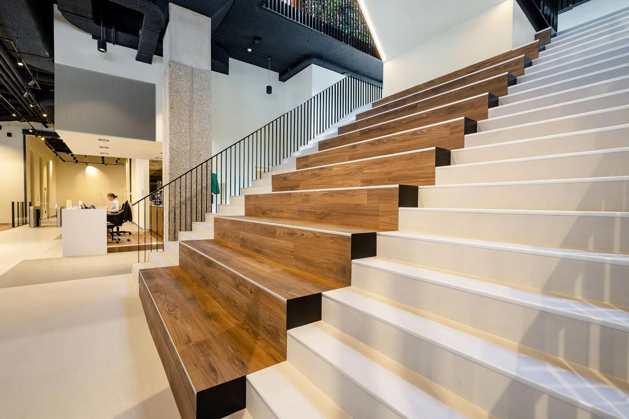 Moderne trap met geïntegreerde zitplekken van hout in het interieur van een gebouw aan de Aert van Nesstraat.